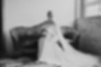 Black And White Bride Posing On Couch In Bridal Suite