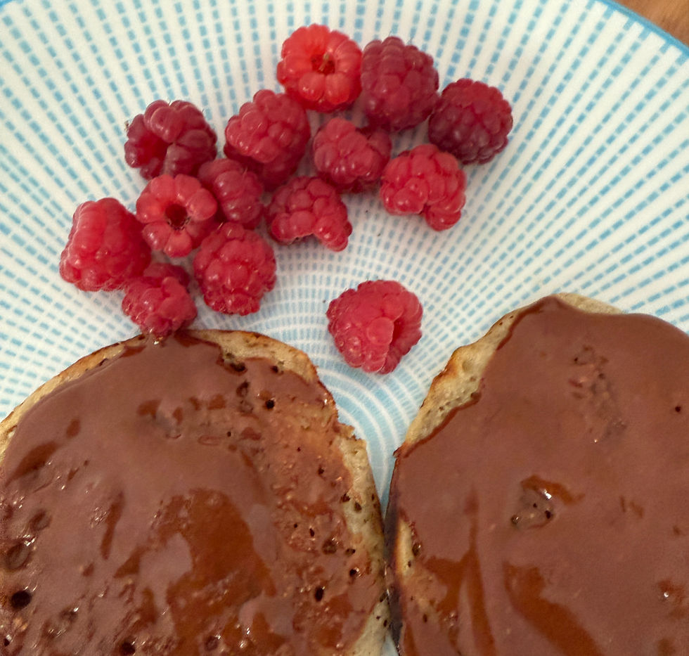 Healthy chocolate hazelnut spread with crumpets and raspberries.
