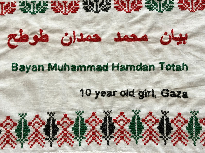 Tatreez patterns of coffee beans and the tree of life embroidered on a doily with the name of Bayan Mohammed Hamdan Totah, a 10-year-old girl from Gaza. The name has been embroidered in English and Arabic.