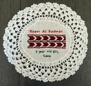 Tatreez pattern of a palm tree embroidered on a doily with the name of Reem Ali Badwan, a 3-year-old girl from Gaza. The name has been embroidered in English.