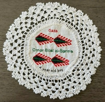 Tatreez pattern of the tree of life embroidered on a doily with the name of Omar Bilal al-Banna , a 4-year-old boy from Gaza. The name has been embroidered in English.