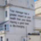 A black and white printed message about effective leadership on a large building wall