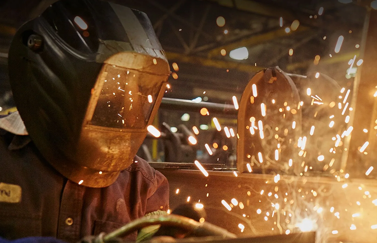 worker-dark-suit-grinding-steel-structure-modern 1.png