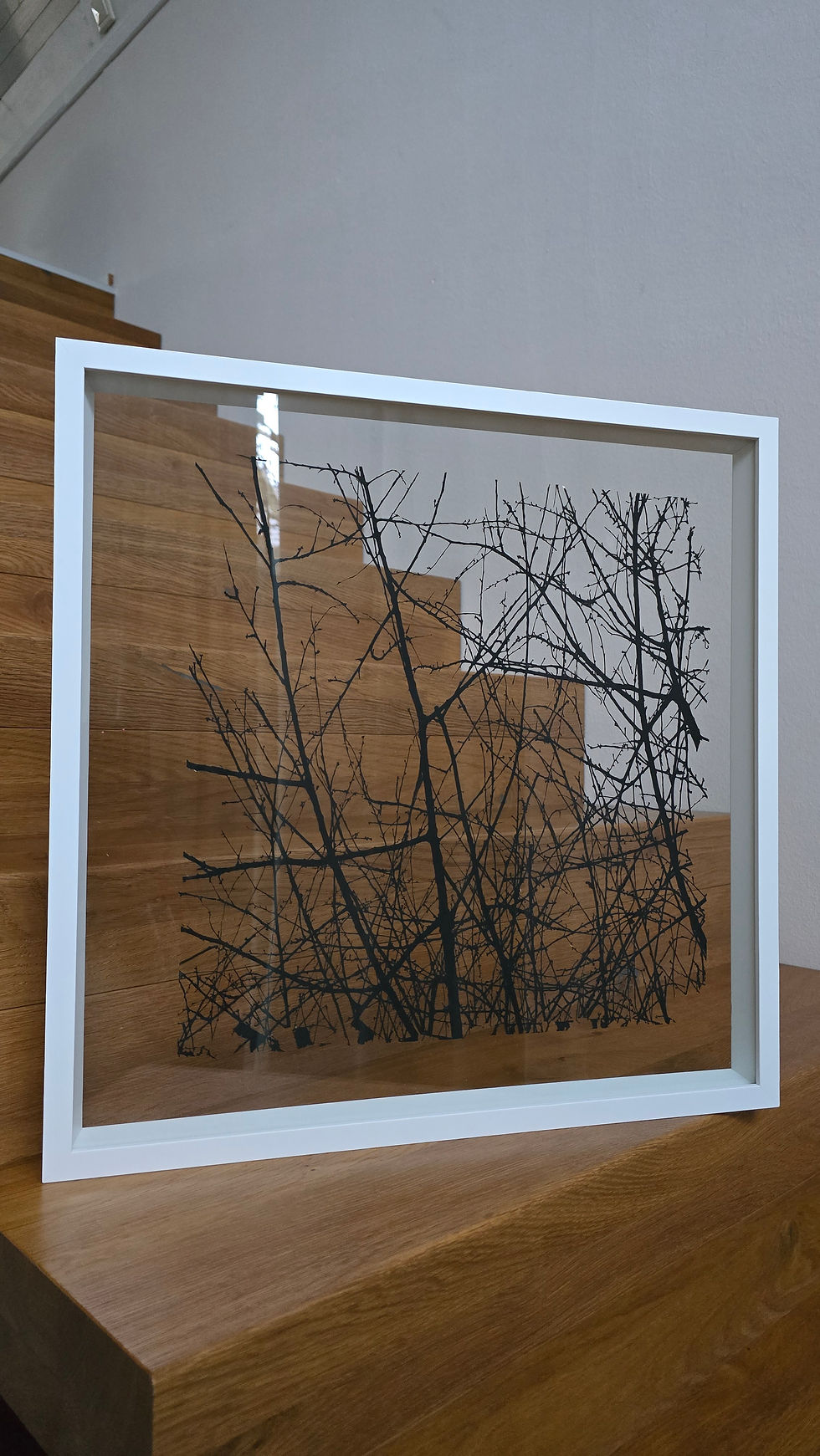 Lasercut-Papierkunst-Unikat von Oksana Bergen aus Paderborn: filigrane schwarze Äste im schwebenden Doppelglasrahmen, inspiri