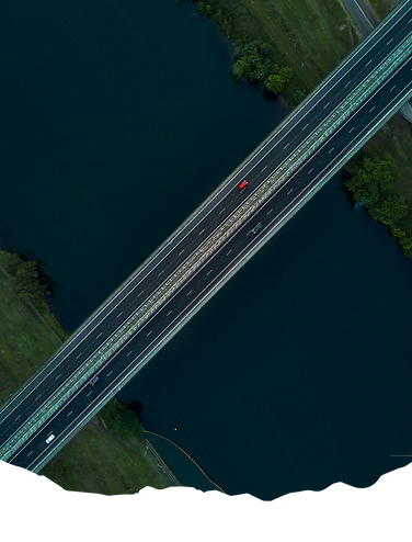 An aerial photo of a highway bridge over a river, symbolizing the ability to bridge gaps in reporting capabilities with Lumen's expertise