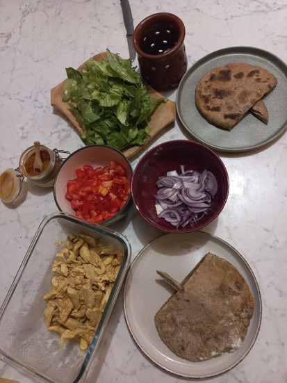 Zöldségek, szószok egy azstalon, mellette upcycled liszttel készült pita