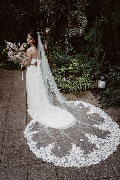 A flower lace veil worn by a model within a glasshouse