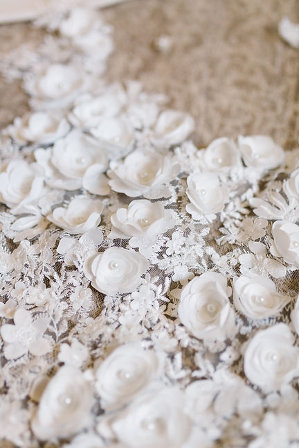 A flower lace veil seen close-up, showcasing the flowers accented with pearls