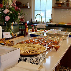 Food spread with chips and dips on a kitchen island for an intimate event.