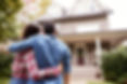 A happy couple standing outside of a house