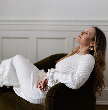 Kari Kazer relaxing with eyes closed in a green velvet chair during a mindfulness break.