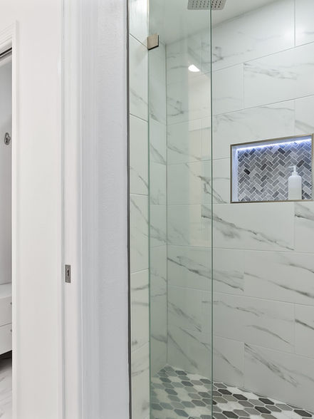 Grey and white tiled shower and glass doors