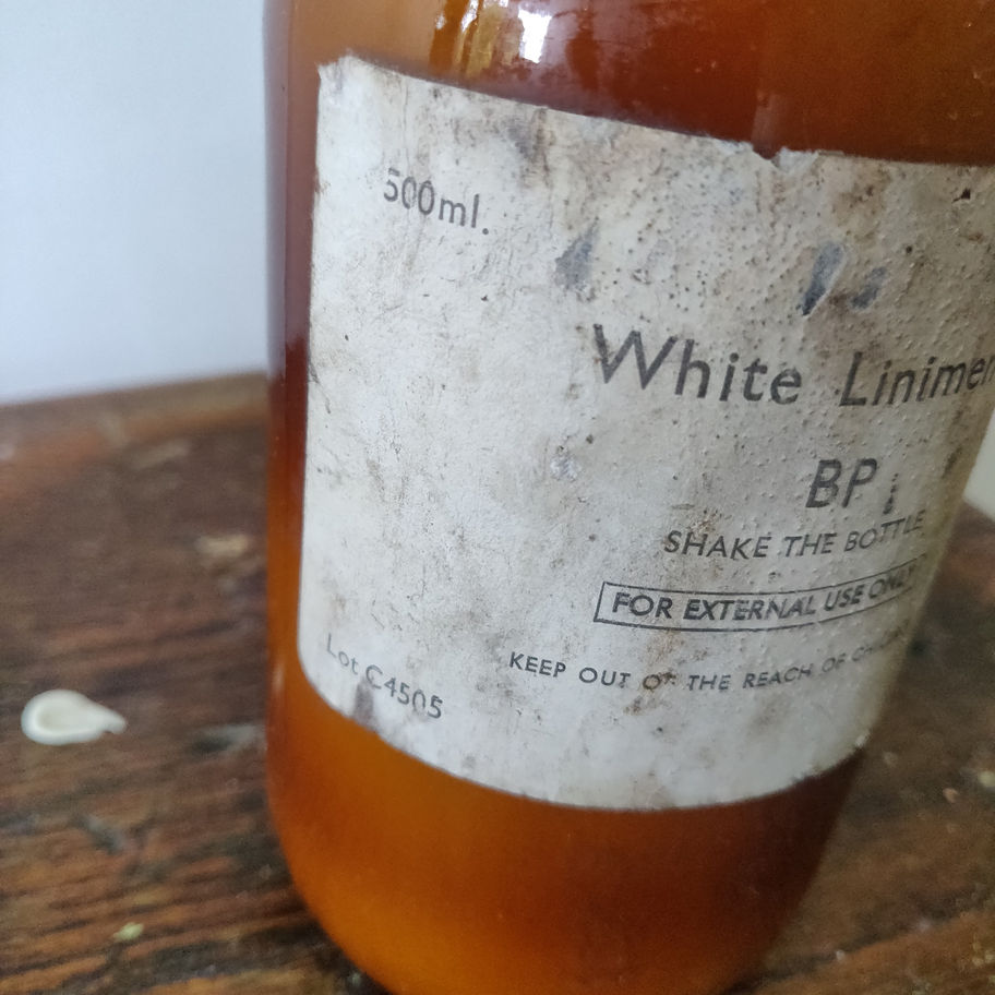 Vintage 1950s white liniment (some contents remain) apothecary/ chemist bottle