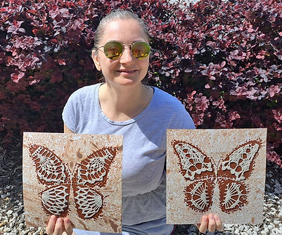 Artist holding a mixed media butterfly diptych on paper in brown shades