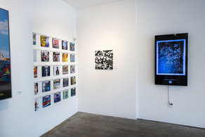 Exhibition space with physical artworks and digital screen