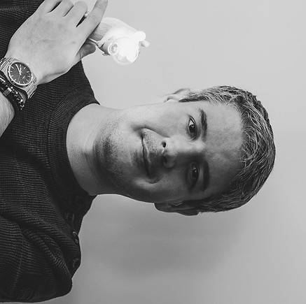 Karl, Web Developer at Vigilitech holding a lit mouse lamp.