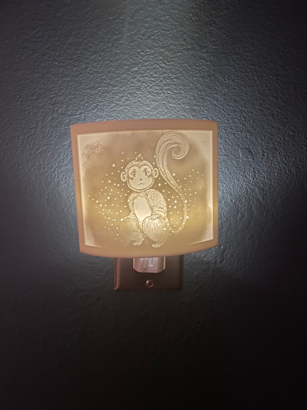 Thumbnail: A nightlight of a monkey with a wispy tail, a bow in her hair, and sparkles all around her.