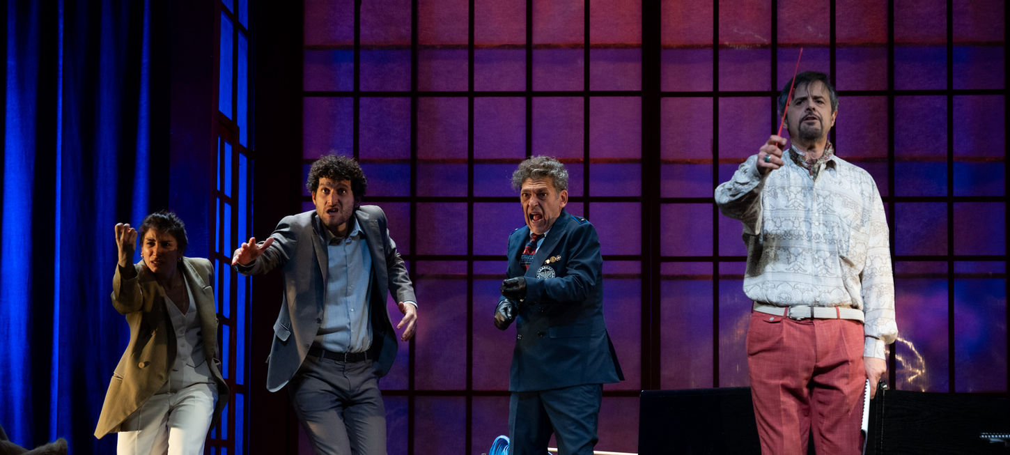 nella foto ci sono 4 dei personaggi di "A Mirror. Uno Spettacolo Falso e non Autorizzato" che sono in movimento di corsa verso la camera. Lo sfondo è una parete viola con riquadri. Lo spettacolo andrà in scena al Teatro Bobbio de La Contrada di Trieste