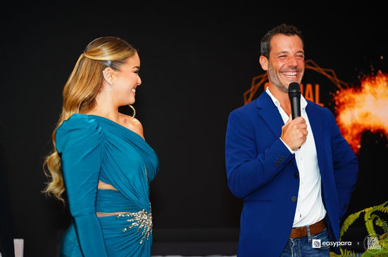 Jocelin Haas sourit avec un micro à la main et une femme