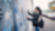 Young woman in front of Berlin Wall. (1)