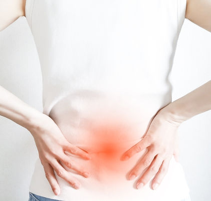 腰痛で腰をおさえる女性