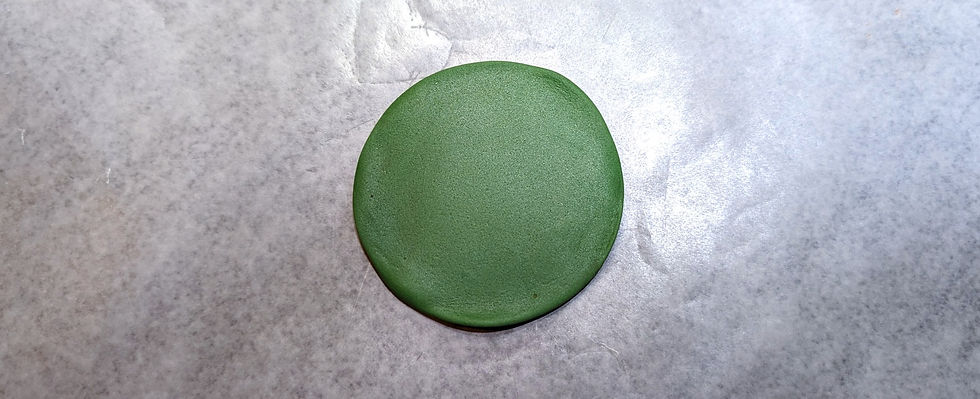 Green fondant rolled flat onto a was sheet of paper.