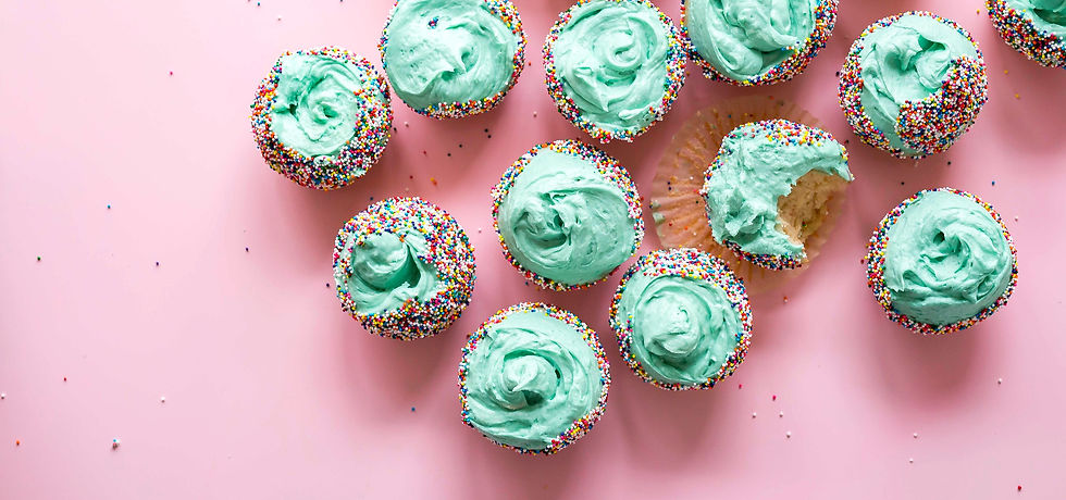 Green frosted cupcakes sitting on a pink background.