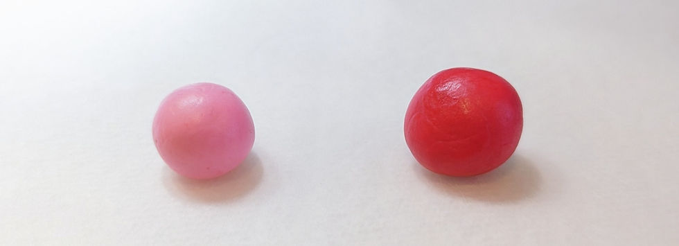Picture of two coloured fondant balls, one red and the other pink..