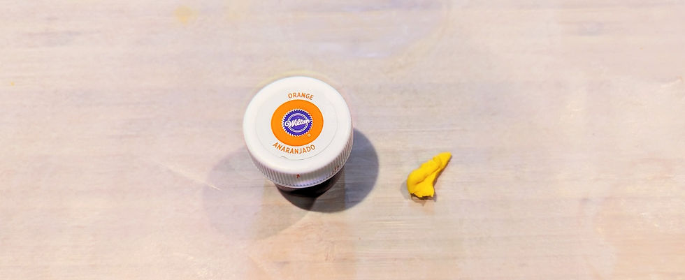 Wilson's Orange Food Dye container sitting beside small piece of yellow coloured fondant.