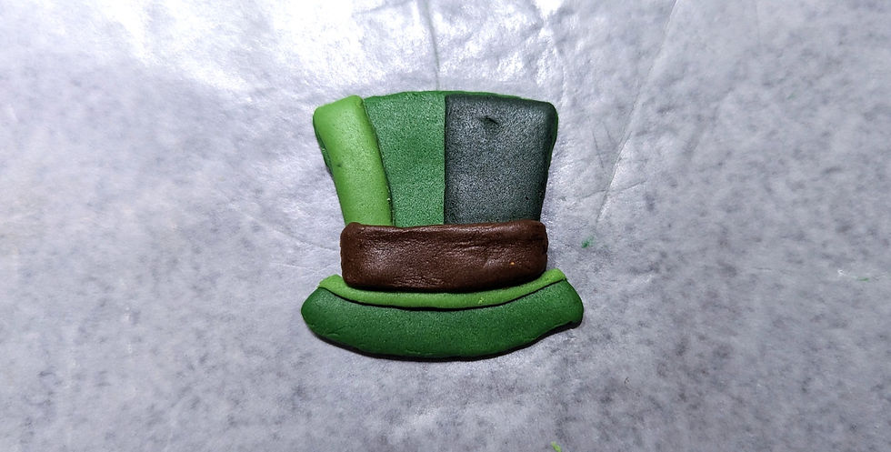 A green fondant top hat cutout with layered fondant shading..