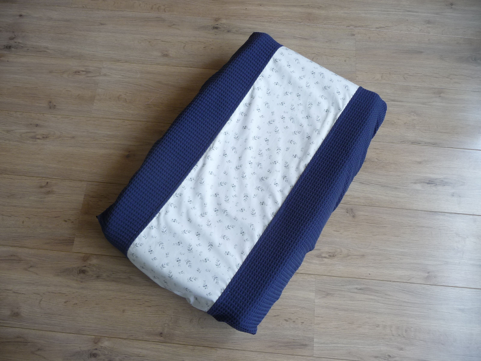 Donkerblauw aankleedkussenhoes van wafelstof met zeegroene blaadjes