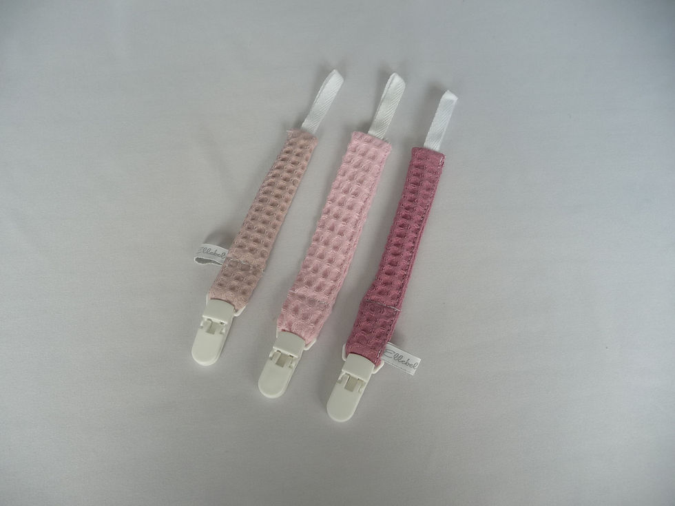 Drie speenkoorden van wafelstof in verschillende roze kleuren