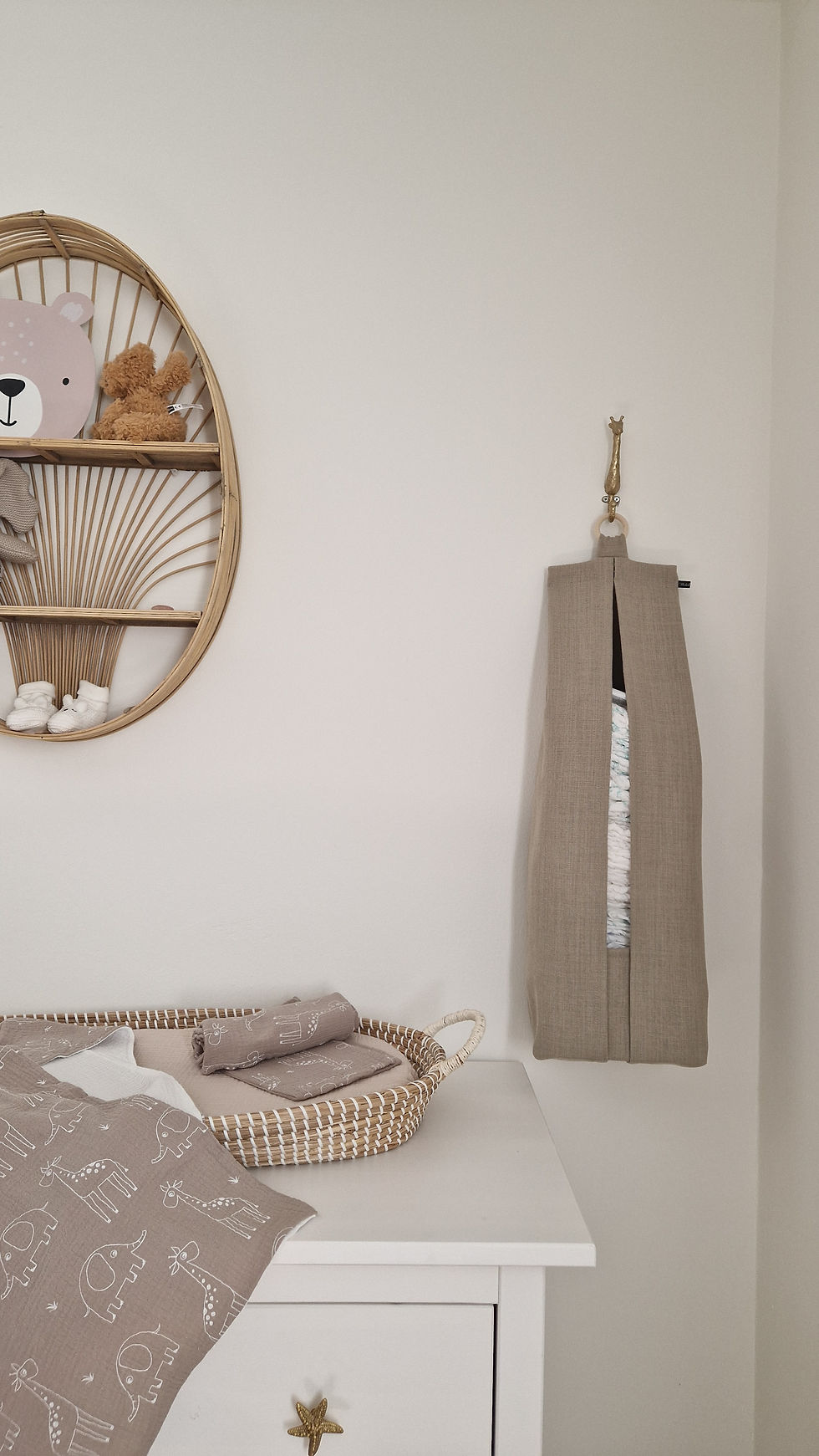 Luieropbergzak hangend aan de muur naast commode