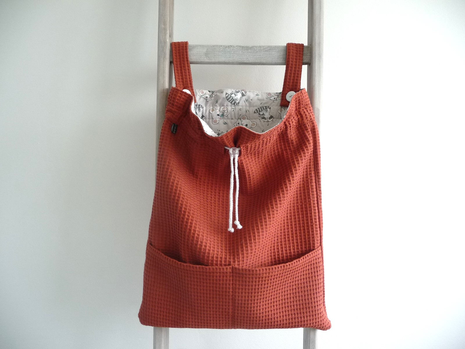 Boxzak voor je baby in een mooie terra kleur, gevoerd met print van koala's en wasberen