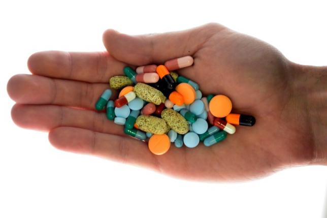 A person holds pharmaceutical tablets and capsules in this picture illustration taken in Ljubljana September 18, 2013. REUTERS/SRDJAN ZIVULOVIC
