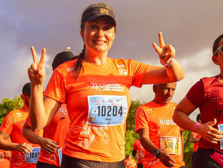 mulher correndo, vestida com a camisa da edição anterior da maratona
