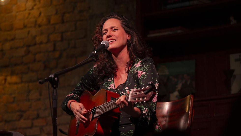 cantora se apresenta tocando violão