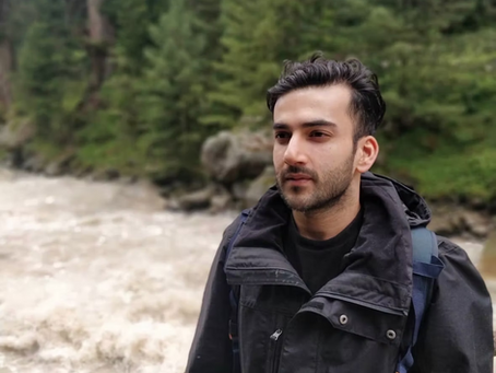 Siddhant Mahajan standing against a river