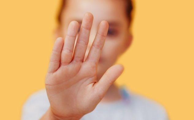 Kind streckt die Hand aus und sagt damit STOPP