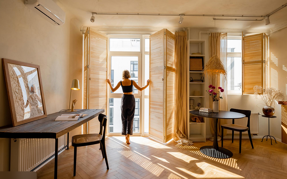 Femme ouvrant des châssis modernes laissant entrer la lumière naturelle dans une maison.