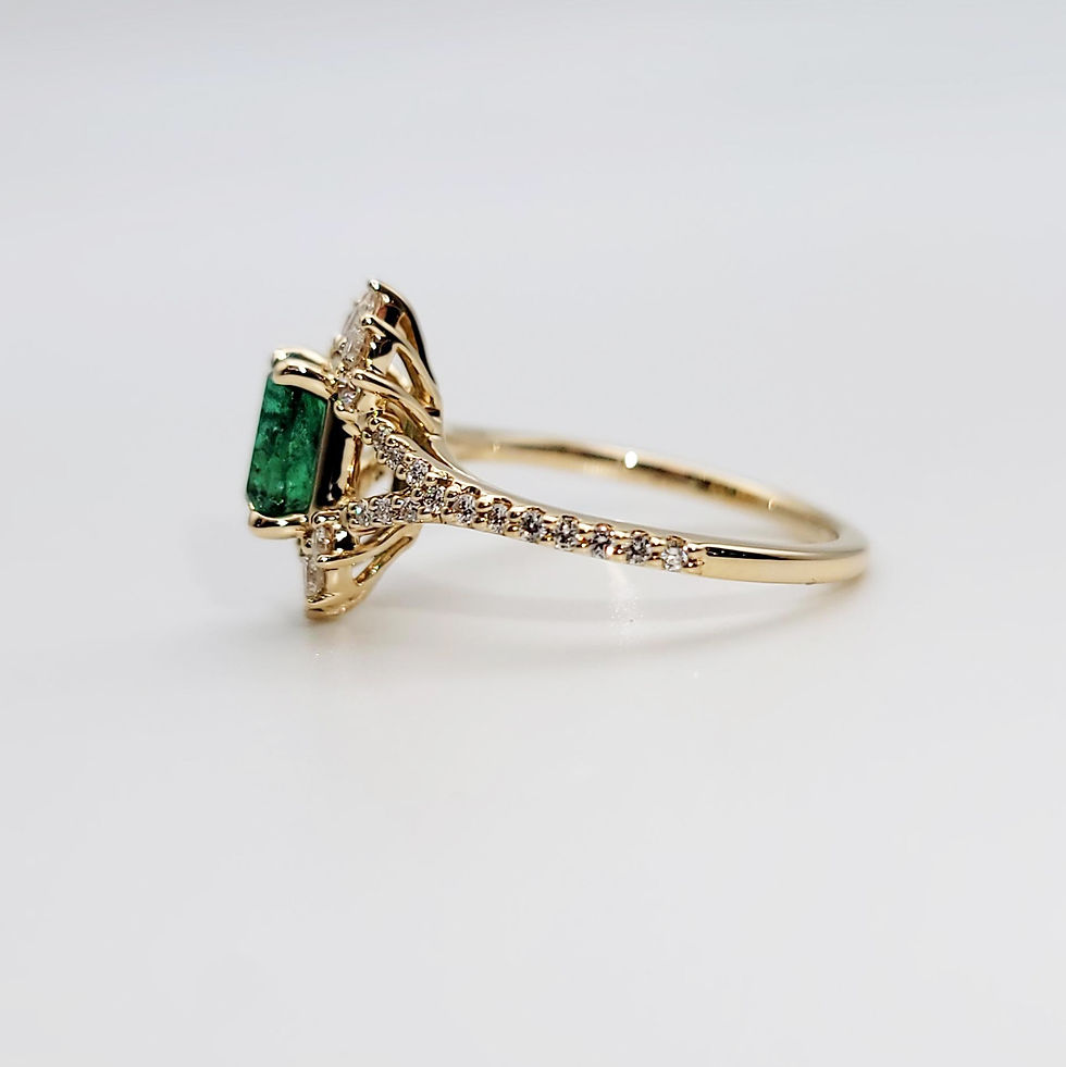 Thumbnail: A close-up side profile of an emerald and diamond gold ring, showcasing the delicate detailing on the band and setting.