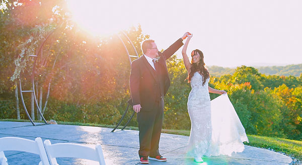 Bride and groom sharing a joyful dance at sunset on the outdoor patio of The Pavilion at Howe Farms, surrounded by vibrant fall foliage, beautifully captured by VE Videography.