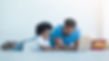 Father and son lying on floor using lapt