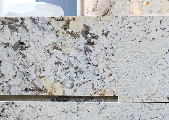 Neue Ausstellungsküche im Küchenatelier Hamburg: Transluzenter Granit ‘White Tiger’ mit hinterleuchteter Rückwand und Echtholzfronten in Davos. Die massive Insel kombiniert Licht, Struktur und natürliche Materialien zu einem modernen Küchen-Statement.