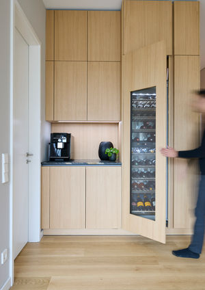 Designküche im Penthouse Hayns Park, realisiert vom Küchenatelier Hamburg: Hochwertige Einbauküche mit furnierten Eichenfronten, Naturstein-Arbeitsplatte aus Belvedere, massiven Eichendielen und durchdachtem Lichtkonzept. Offene Raumgestaltung, elegantes Küchendesign und maximaler Stauraum – eine zeitlose Küchenlösung mit natürlichen Materialien.