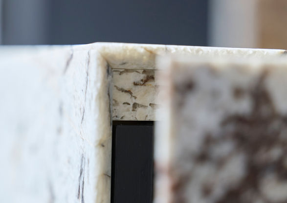 Neue Ausstellungsküche im Küchenatelier Hamburg: Transluzenter Granit ‘White Tiger’ mit hinterleuchteter Rückwand und Echtholzfronten in Davos. Die massive Insel kombiniert Licht, Struktur und natürliche Materialien zu einem modernen Küchen-Statement.