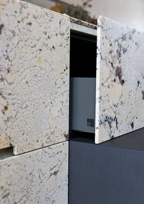 Neue Ausstellungsküche im Küchenatelier Hamburg: Transluzenter Granit ‘White Tiger’ mit hinterleuchteter Rückwand und Echtholzfronten in Davos. Die massive Insel kombiniert Licht, Struktur und natürliche Materialien zu einem modernen Küchen-Statement.