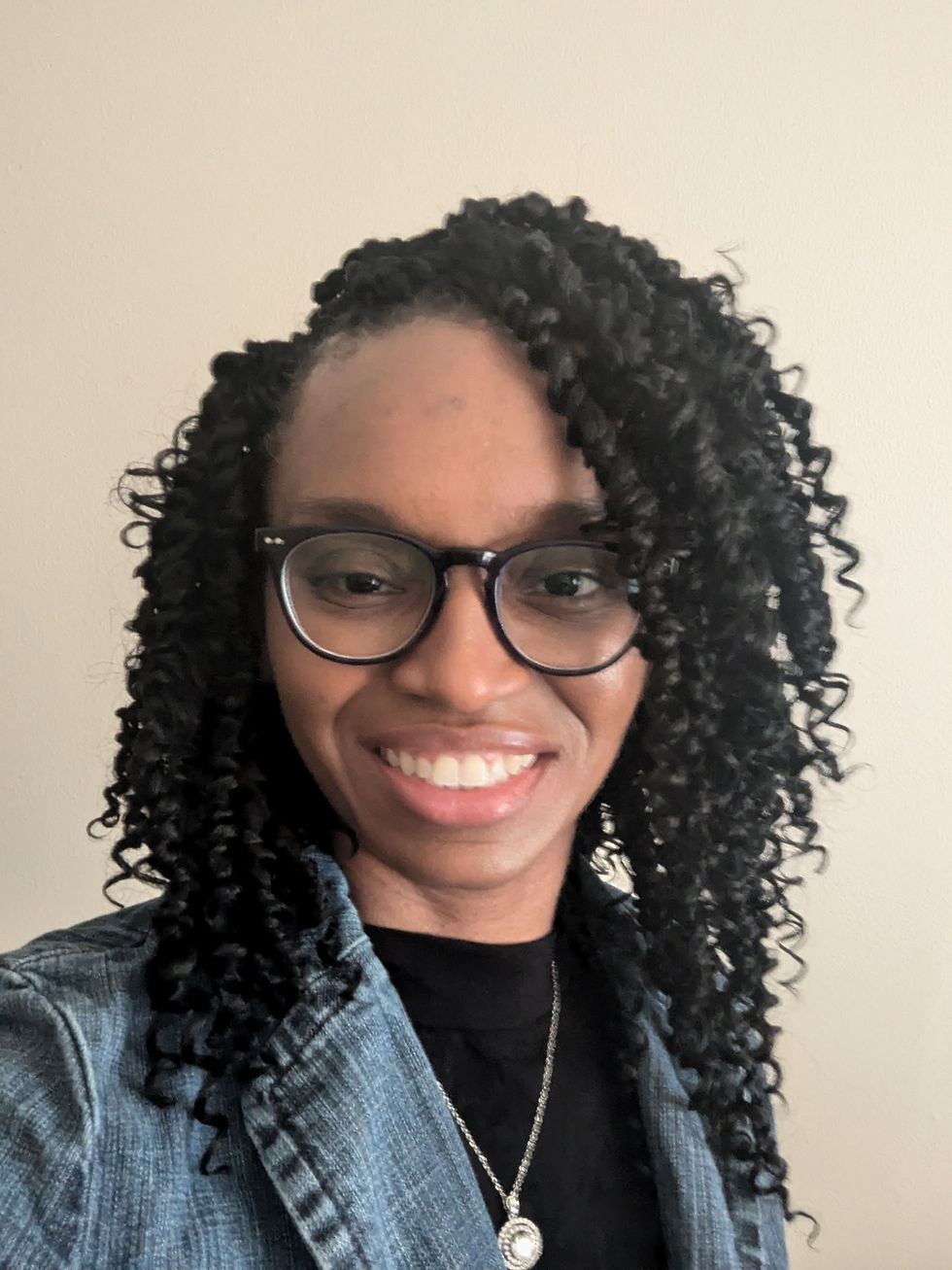 Smiling woman with curly hair and glasses
