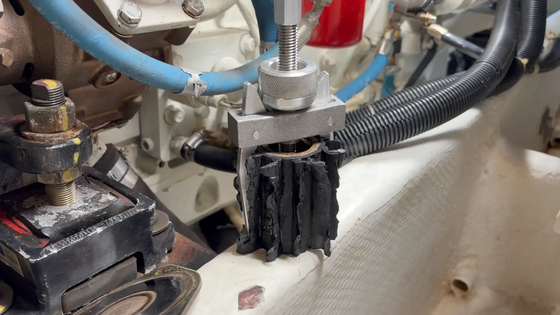 ImpelPro Large Impeller Puller gripping a heat destroyed marine impeller in an engine room. 