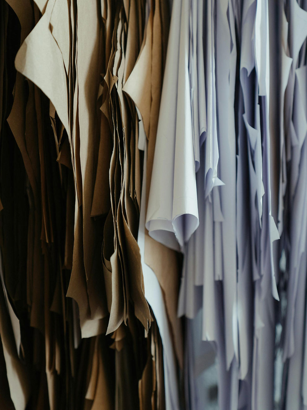 Brown and black sneaker steps on foliage next to a terracotta pot. Background includes flowers and greenery. Floral-patterned leggings.